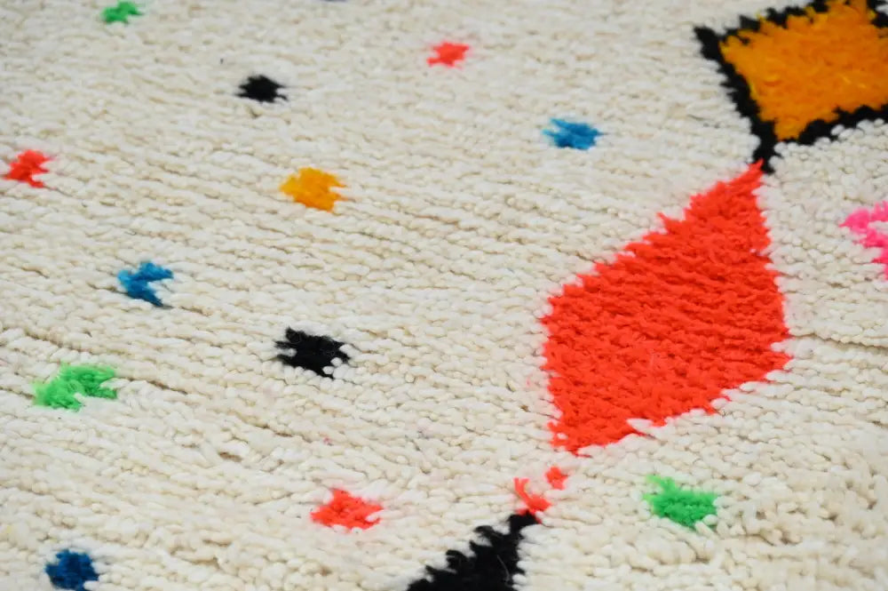 Cream-colored moroccan handmade traditional azilal rug with vibrant orange red black blue and green geometric patterns