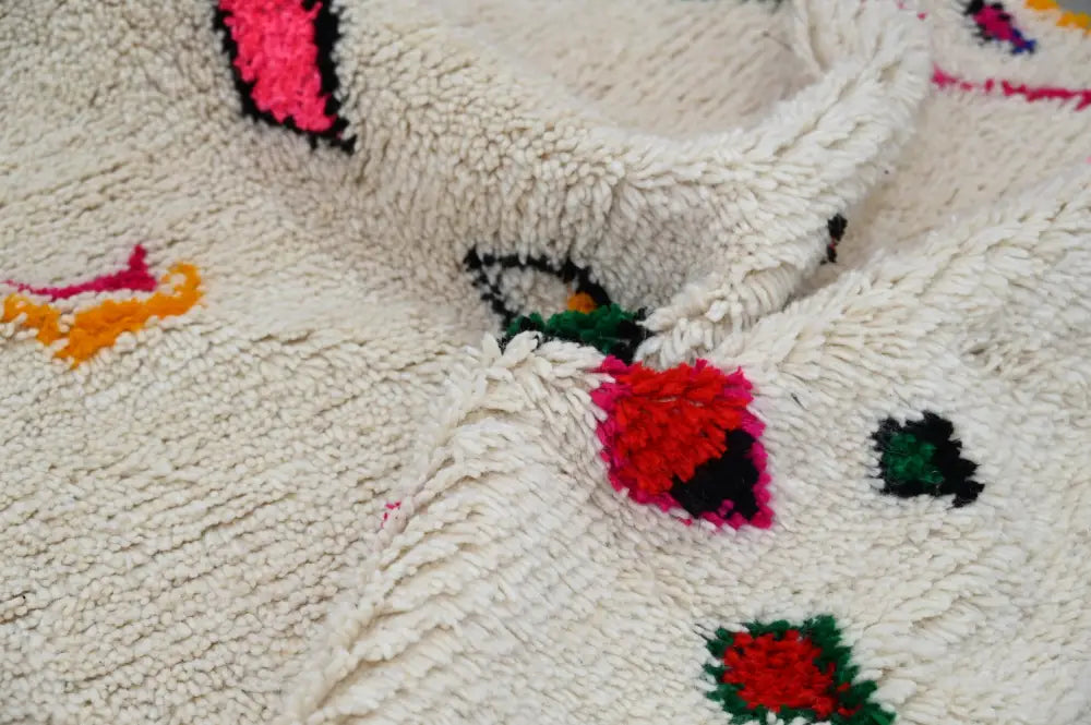 Cream-colored moroccan handmade traditional azilal rug with fluffy texture and vibrant geometric patterns by decorbites