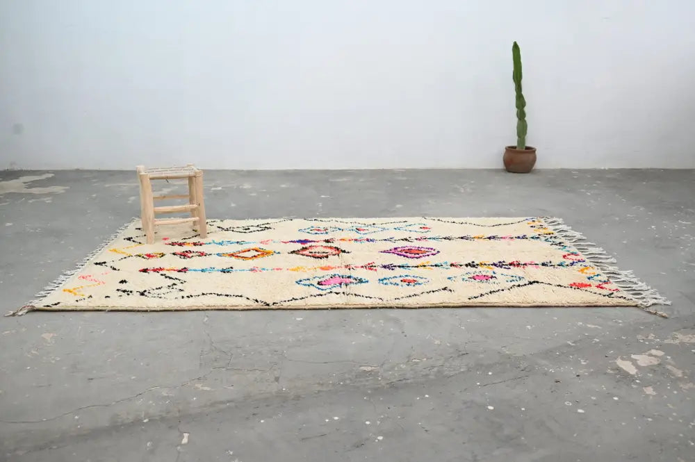 Beige moroccan handmade traditional azilal rug with colorful geometric patterns and fringed edges by decorbites