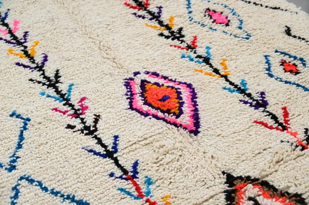 Cream-colored moroccan handmade traditional azilal rug featuring vibrant multicolored geometric and tribal patterns