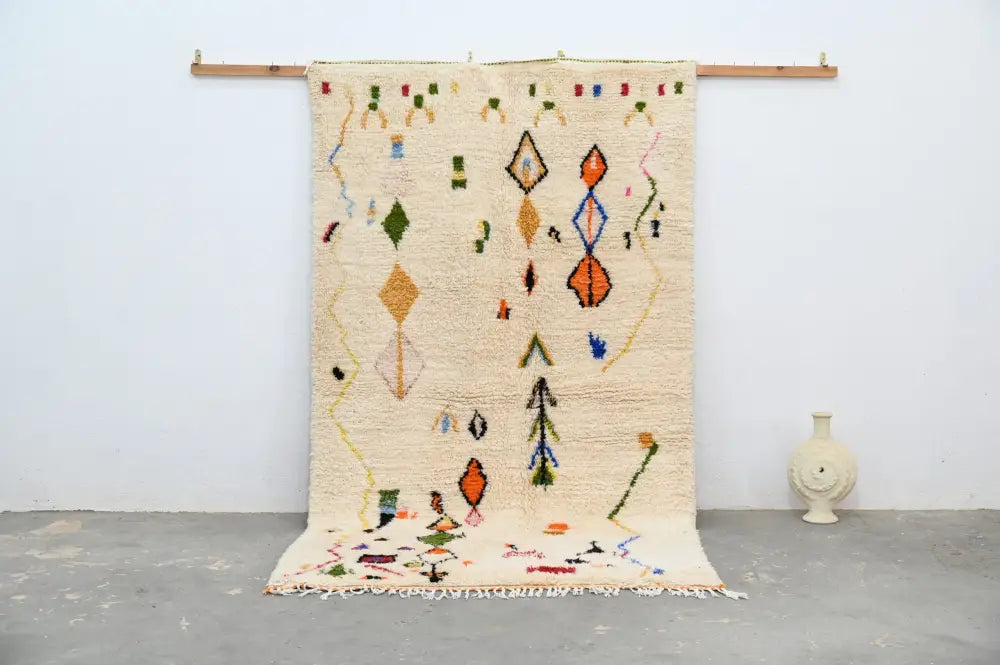 Beige moroccan handmade traditional azilal rug with colorful geometric patterns and fringed edges by decorbites