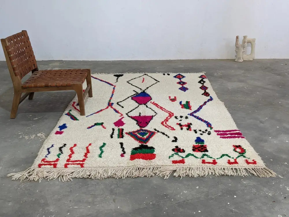 Cream-colored moroccan handmade azilal rug with vibrant geometric patterns in pure natural wool and fringed edges
