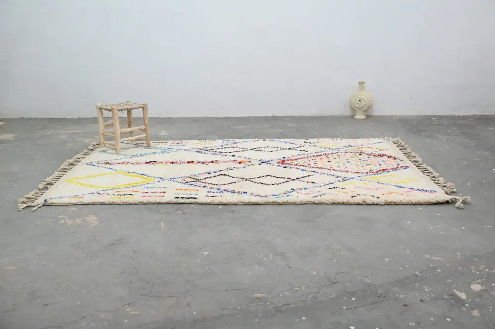 Cream-colored DecorBites™ moroccan handmade traditional azilal rug with intricate multicolored geometric patterns and fringed edges