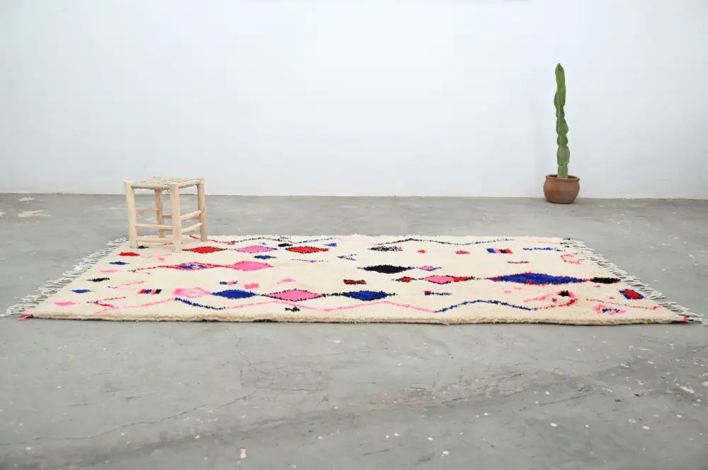 Cream-colored moroccan handmade traditional azilal rug with vibrant pink blue and black geometric patterns 273 x 151 cm