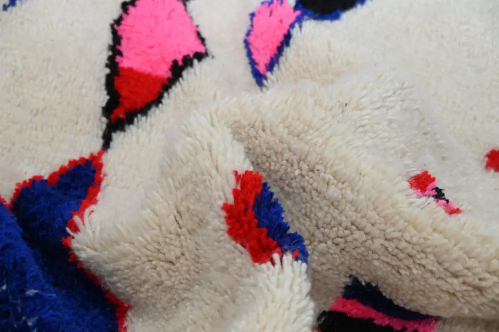 Cream-colored plush wool moroccan handmade traditional azilal rug with bold pink red and blue geometric patterns 273 x 151 cm