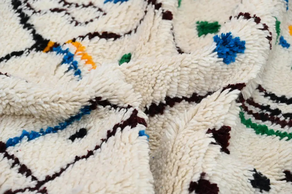 Cream-colored moroccan handmade traditional azilal rug with plush wool and bold blue green orange geometric patterns 273 x 155 cm
