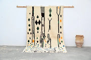 Beige moroccan handmade traditional azilal rug with black green and orange geometric patterns 273 x 155 cm by decorbites