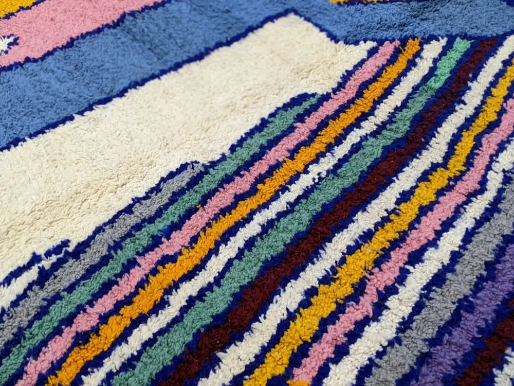 A plush multicolored moroccan handmade traditional azilal rug featuring bold diagonal stripes in pink yellow green blue and white