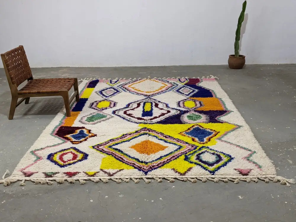 Vibrant geometric-patterned moroccan handmade traditional azilal rug with cream base and bold multicolor wool accents