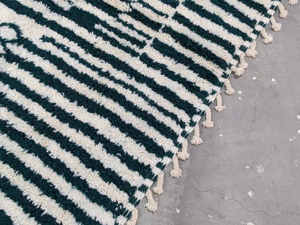 A plush moroccan handmade traditional azilal rug in deep teal and off-white with soft tassels by decorbites