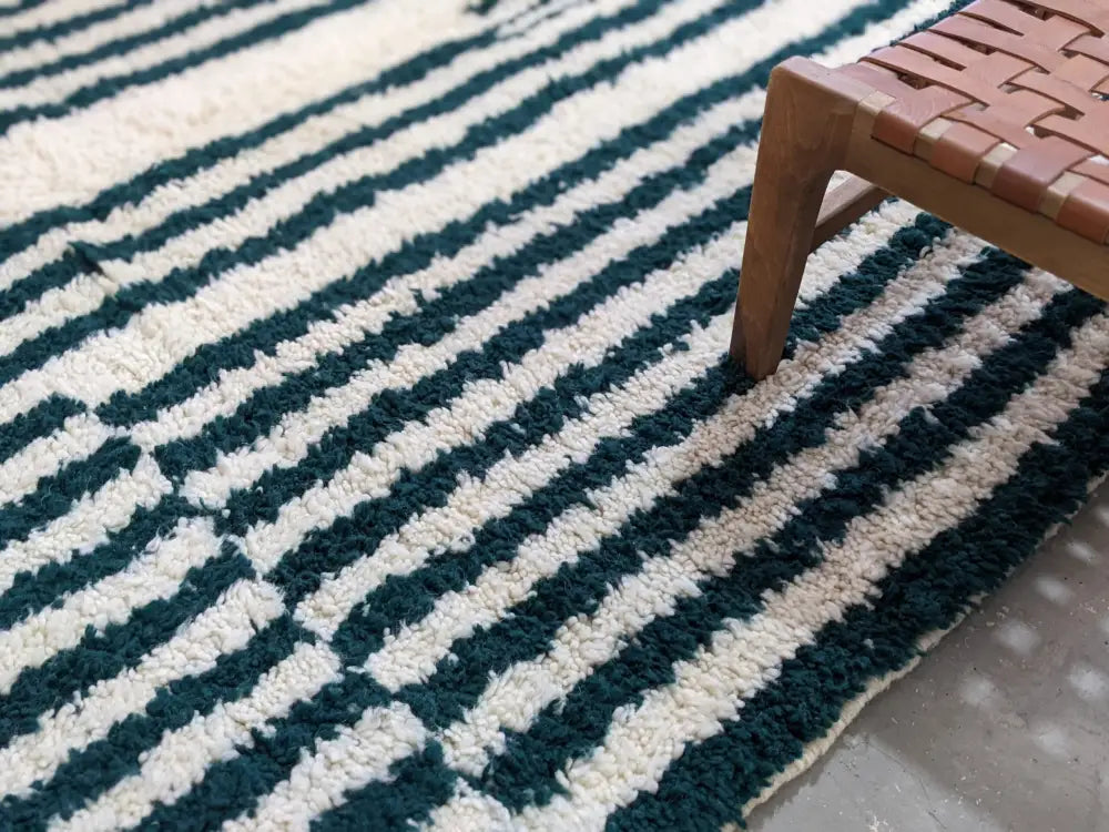 A plush high-pile moroccan handmade traditional azilal rug with bold diagonal deep teal and off-white stripes 316 x 206 cm
