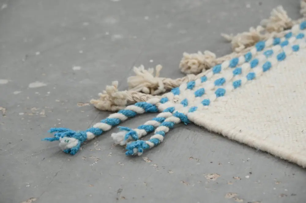 Blue and white braided rope tassels with frayed ends on moroccan handmade traditional azilal rug by decorbites