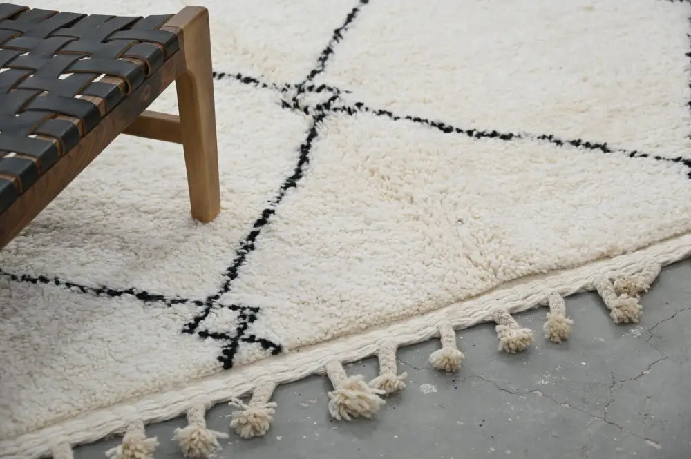 Cream-colored moroccan handmade beni ouarain carpet with black geometric patterns and fluffy tassels 310 x 215 cm