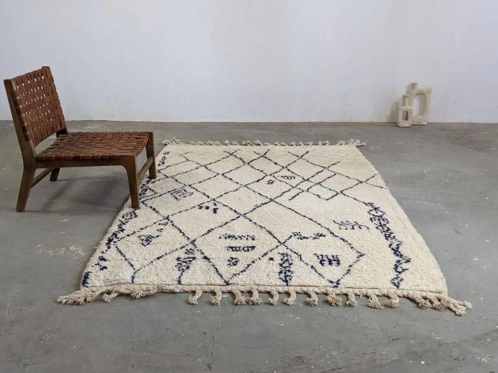 Cream-colored moroccan handmade beni ouarain rug with black geometric patterns and fringed edges 244 x 157 cm