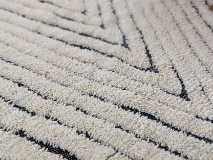 Cream-colored beni ouarain rug with plush textured surface and bold black geometric stripes moroccan handmade decor