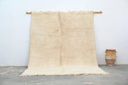 Cream-colored beni ouarain rug with textured fringed edges moroccan handmade natural fiber traditional design
