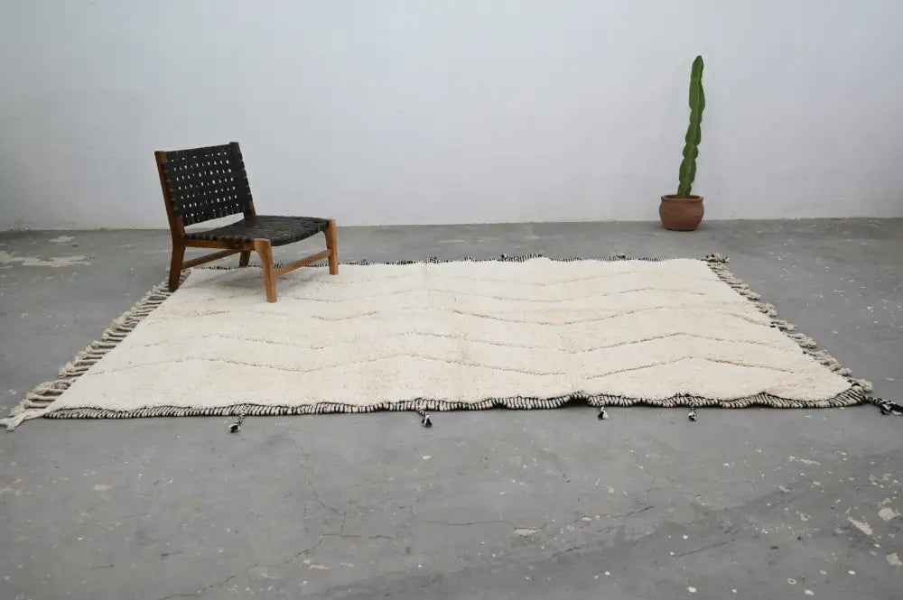 Cream-colored moroccan handmade beni ouarain rug with black zigzag patterns and tassels 290 x 205 cm