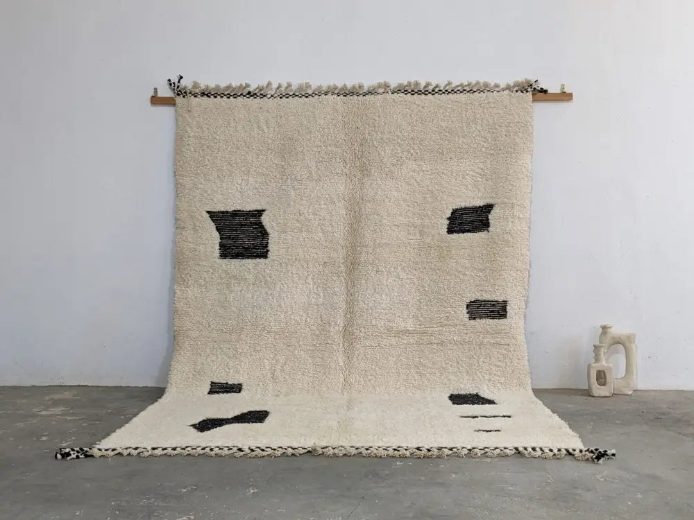 Cream-colored moroccan handmade beni ouarain rug with bold black geometric patches and fringed edges 290 x 210 cm