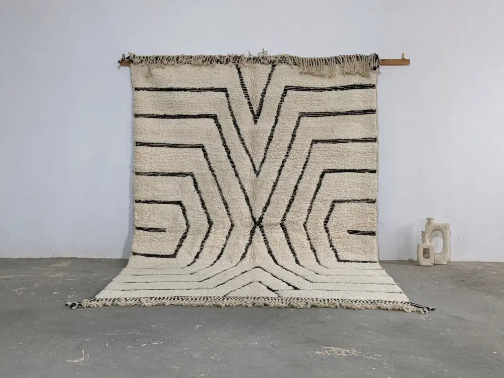 Cream-colored beni ouarain rug with bold black geometric patterns and fringed edges moroccan handmade traditional design