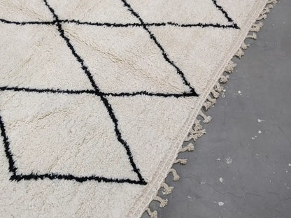 Cream-colored beni ouarain rug with bold black geometric patterns and fringed edges moroccan handmade traditional design