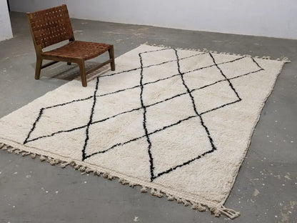 Cream-colored moroccan handmade beni ouarain rug with black geometric diamond pattern and fringed edges 292 x 202 cm