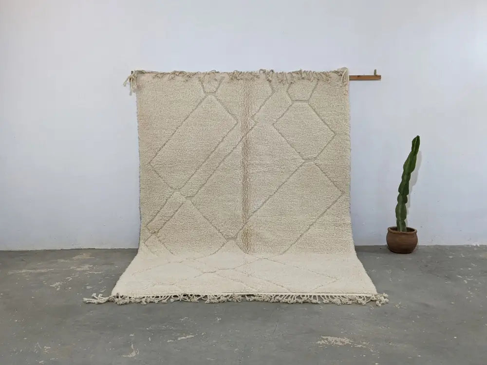 Cream-colored moroccan handmade beni ouarain rug with a textured surface and geometric diamond pattern 295 x 214 cm