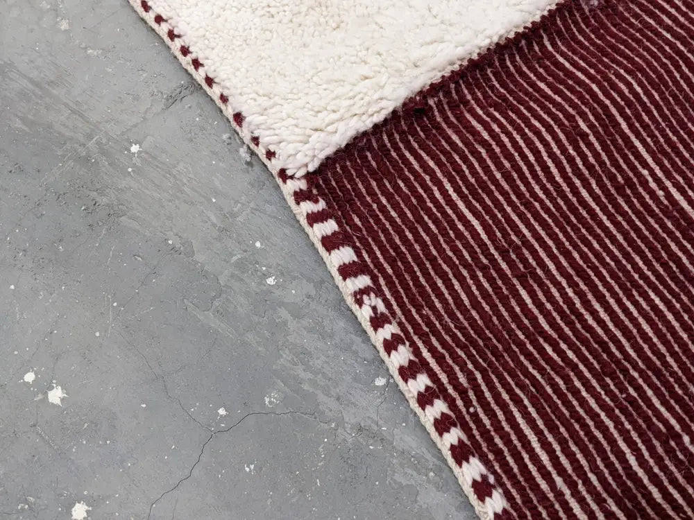 Maroon and cream striped moroccan handmade beni ouarain rug with plush textured wool surface and hand-stitched border