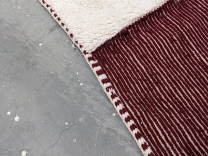 Maroon and cream striped moroccan handmade beni ouarain rug with plush textured wool surface and hand-stitched border