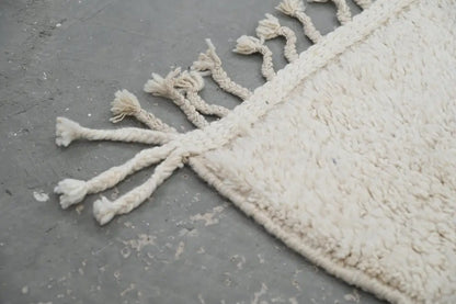 Cream-colored moroccan handmade beni ouarain rug with plush wool texture and braided tassels edge 300 x 200 cm