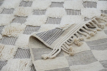 Cream and gray checkered beni ouarain rug with textured fringed edges in a 300 x 203 cm traditional design
