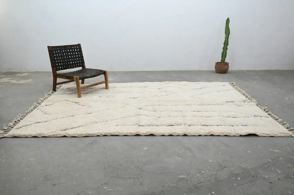 Cream-colored beni ouarain rug with textured wool, fringed edges, and subtle woven patterns moroccan handmade decor piece