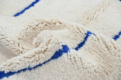 Cream-colored beni ouarain rug with bold blue geometric stripes moroccan handmade traditional shearling blanket