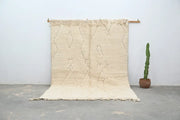 Cream-colored moroccan handmade beni ouarain rug with textured surface and geometric patterns 300 x 208 cm by decorbites