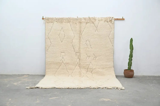 Cream-colored moroccan handmade beni ouarain rug with textured surface and geometric patterns 300 x 208 cm by decorbites