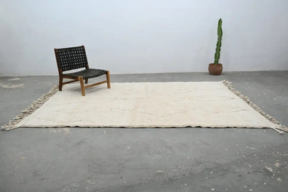 Cream-colored moroccan handmade beni ouarain rug with fringed edges and subtle geometric patterns 300 x 208 cm