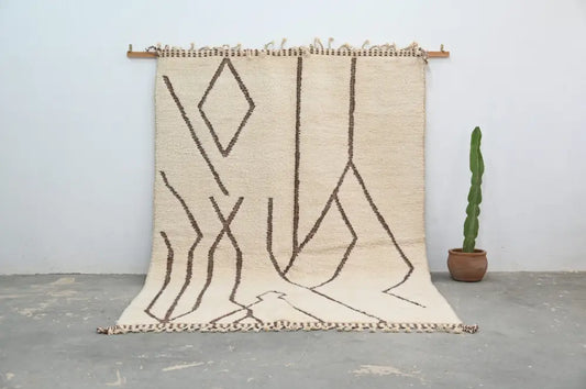 Beige moroccan handmade beni ouarain rug with bold brown geometric patterns and fringed edges by DecorBites™