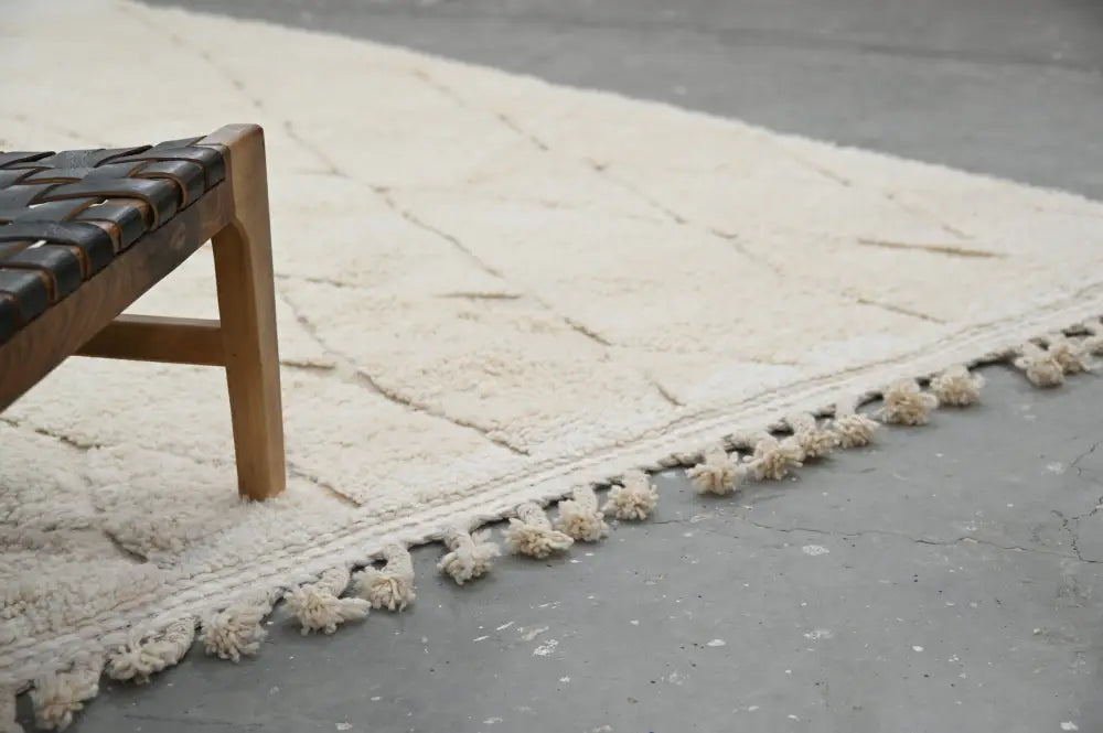 Cream-colored beni ouarain rug with geometric pattern and fluffy tassels made from hand-knotted wool moroccan handmade