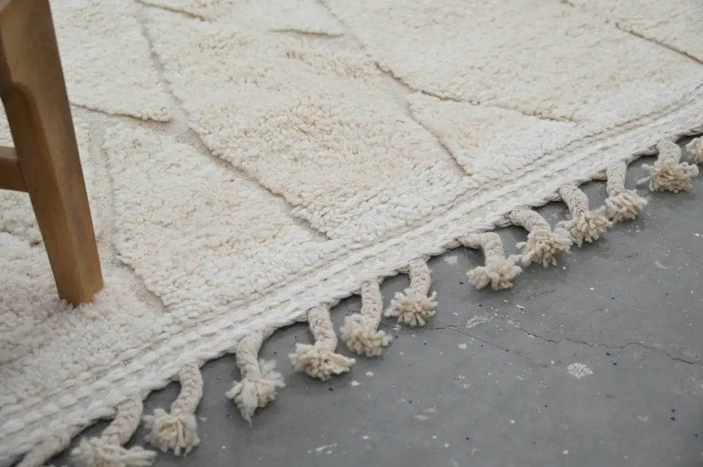 Cream-colored beni ouarain rug with geometric pattern and tasseled fringe moroccan handmade traditional decorbites