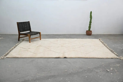 Cream-colored moroccan handmade beni ouarain rug with diamond pattern and fringed edges 300 x 212 cm by DecorBites