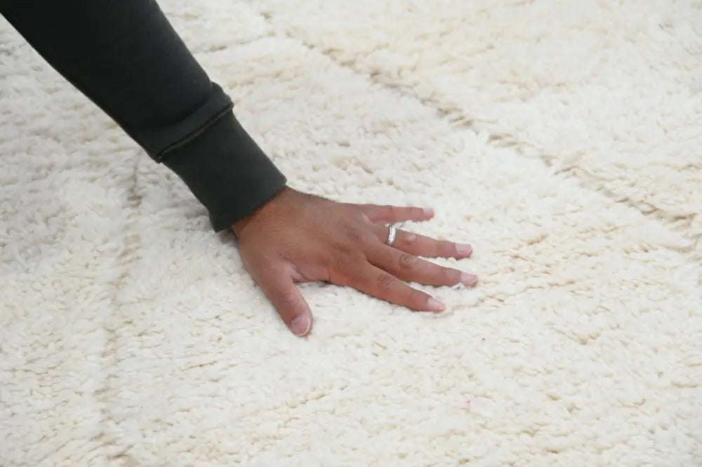 A soft off-white moroccan handmade beni ouarain rug with a plush textured surface 302 x 200 cm by DecorBites
