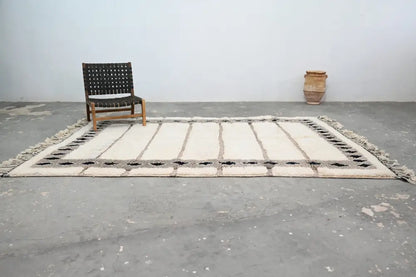 Cream-colored beni ouarain rug with black geometric patterns and fringed edges moroccan handmade wool decorbites
