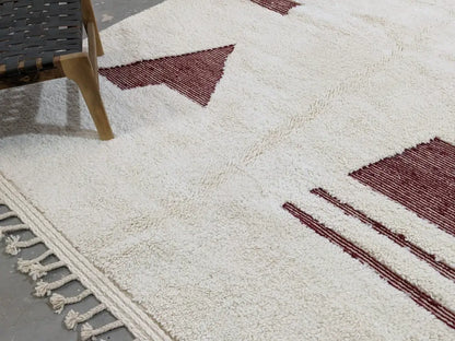 Cream-colored moroccan handmade beni ouarain rug with bold maroon geometric patterns and fringed edge 303 x 214 cm
