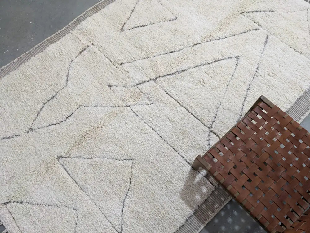 Cream-colored textured wool beni ouarain rug with dark geometric triangle patterns moroccan handmade traditional design