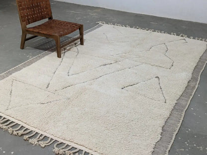 Cream-colored plush wool beni ouarain rug with geometric patterns and fringed edges moroccan handmade decorbites