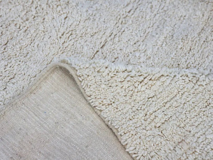 Cream-colored plush shaggy beni ouarain rug with soft textured surface and visible woven backing moroccan handmade