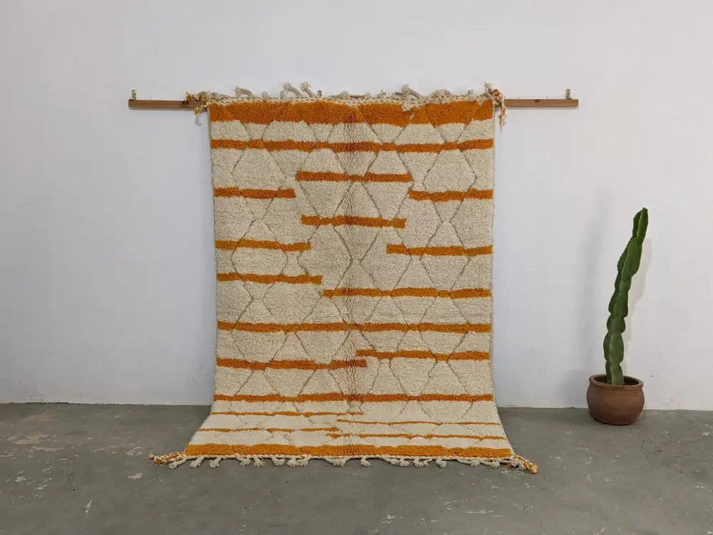 Cream and orange geometric-patterned beni ouarain moroccan handmade rug with fringed edges by decorbites