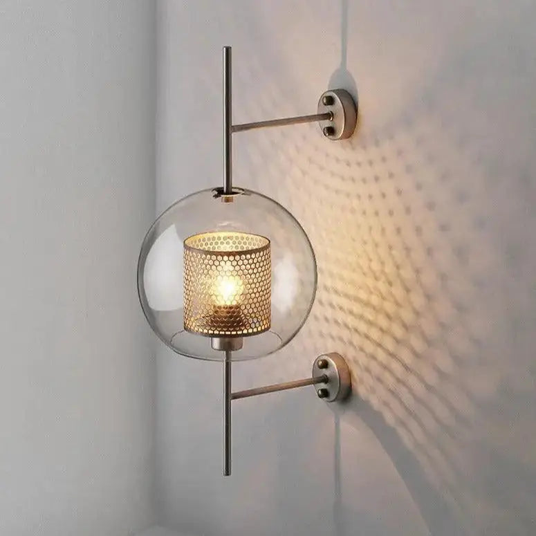 Modern bathroom wall sconce with gold-toned perforated metal shade and clear glass globe from decorbites™ moroccan modern collection