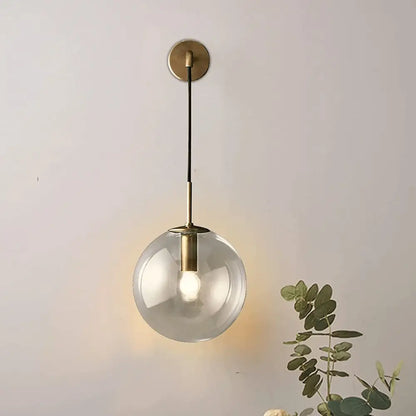 DecorBites™ Moroccan modern wall sconce featuring a spherical glass pendant light with brass finish and black cord