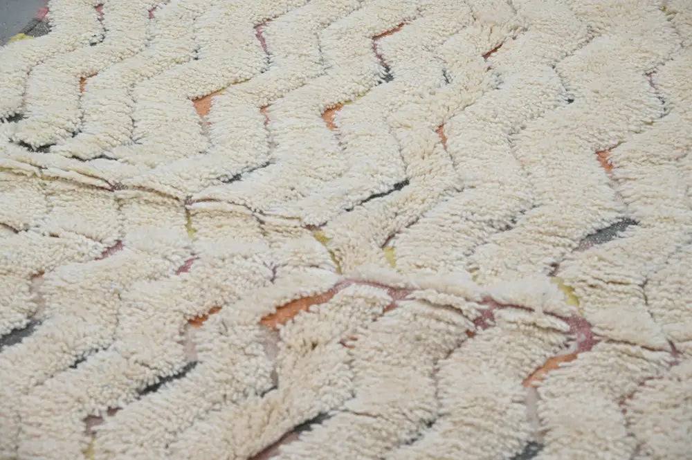 Cream-colored plush shaggy handmade traditional azilal rug with zigzag pattern and pink and gray accents 240x147cm