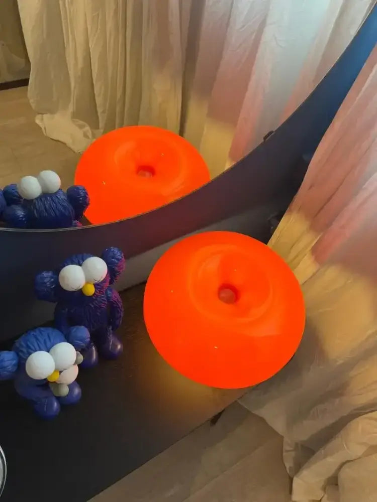 Vibrant orange led mushroom table lamp with central hole and glossy surface for modern bedside or living room decor